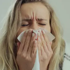 Kobieta z chusteczką przy nosie, martwiąca się jakie leki na covid mogą pomóc.