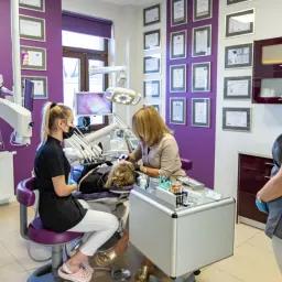 Dentystka i asystentka w gabinecie stomatologicznym podczas zabiegu.
